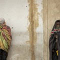 Homeless men stand against the wall on a street of downtown Johannesburg..jpg
